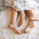 adults barefoot in bed